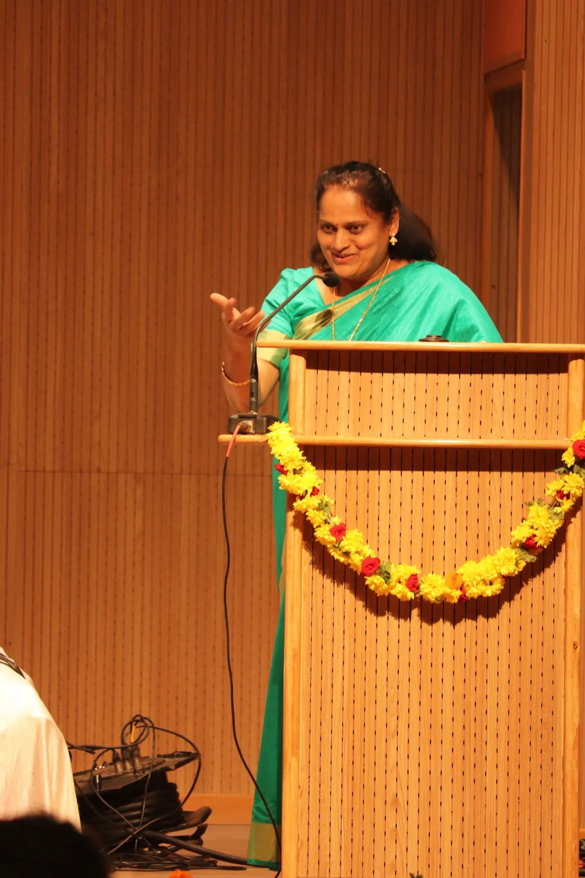 Speaker at garlanded podium