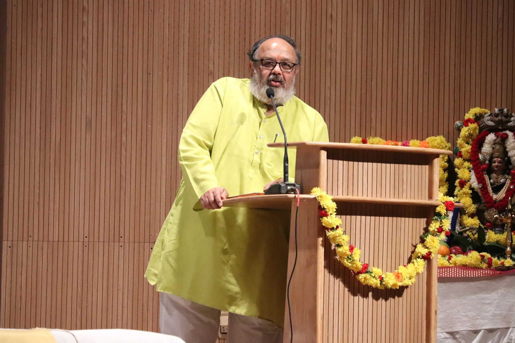 Speaker at podium with shrine