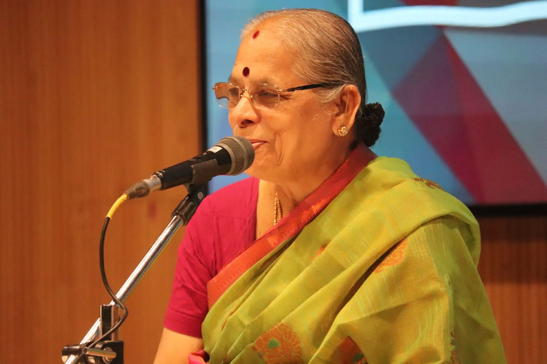 Senior woman singing into mic, smiling
