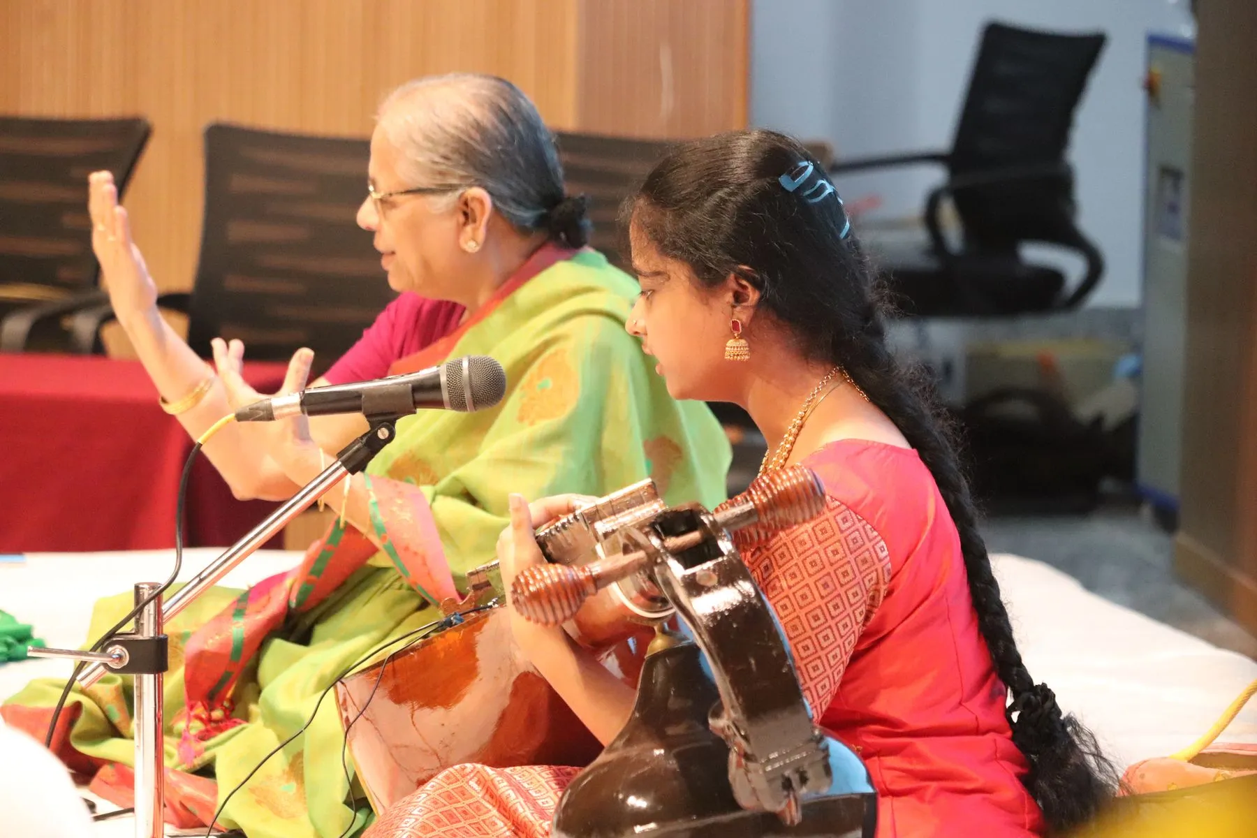 Guru gesturing while student plays