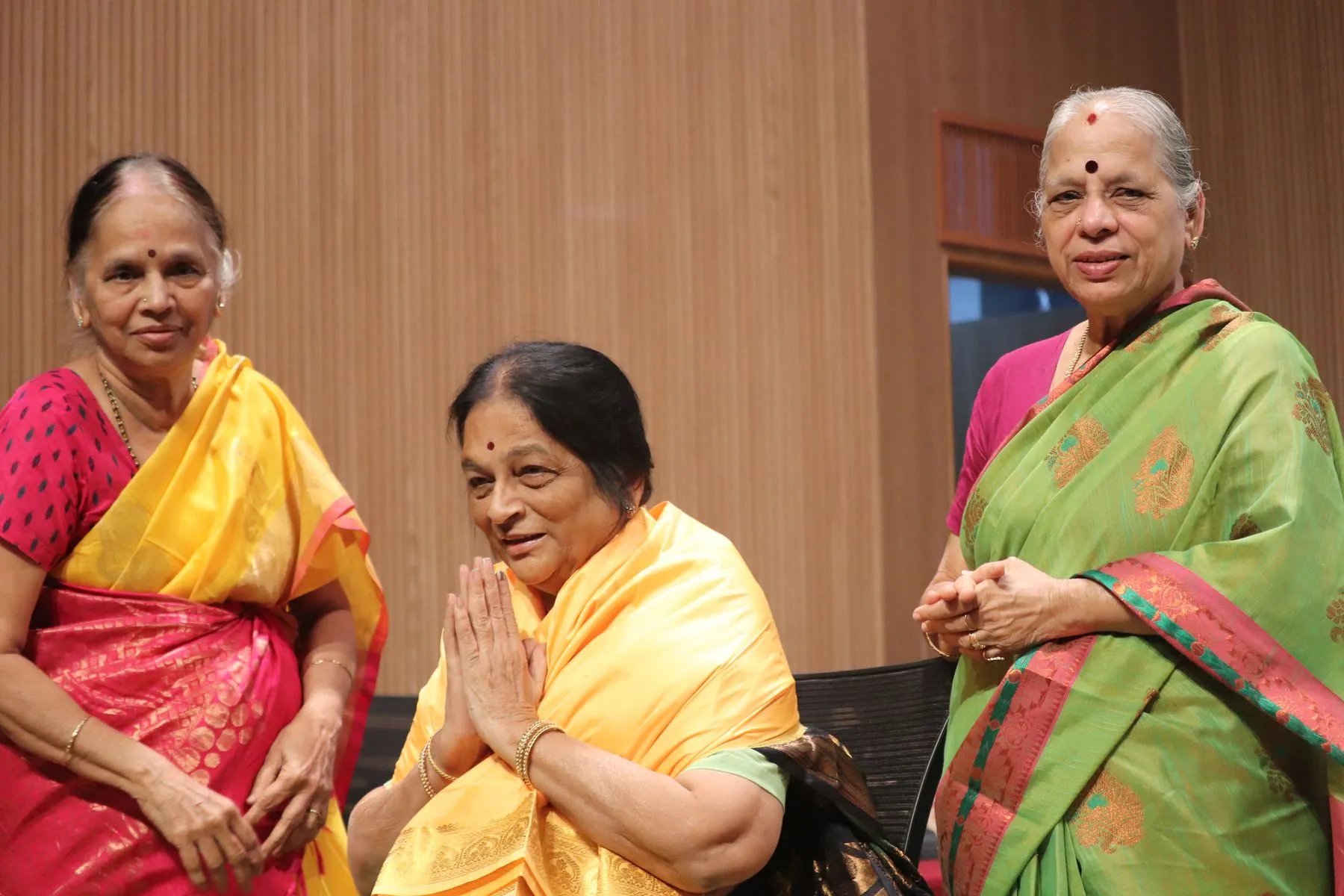 Honoree in namaste between senior women
