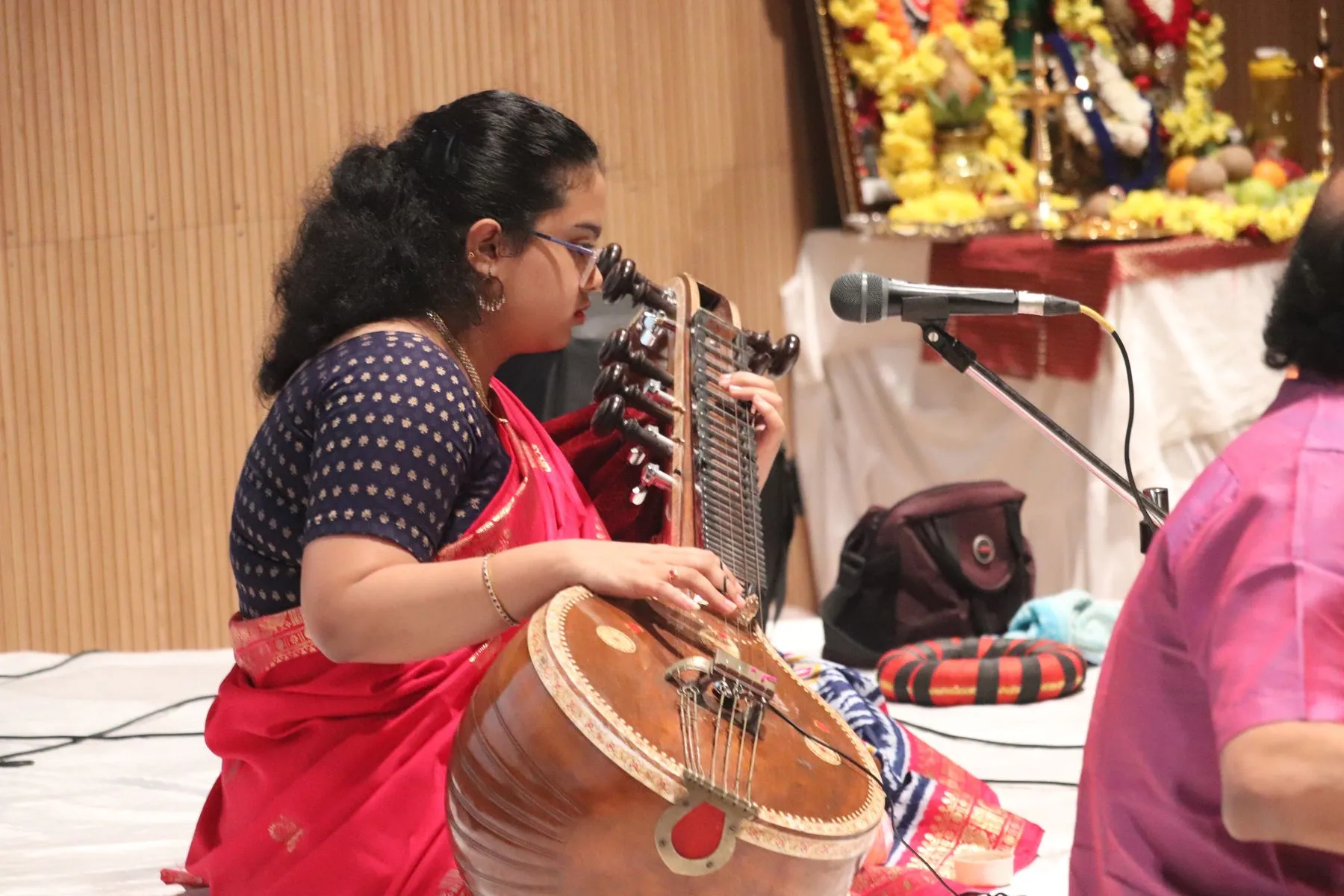 Young vainika in red, intent